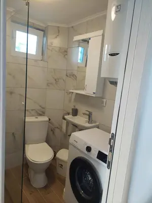 a bathroom with a toilet and a washing machine at Vila Aleksandar in Krčedin