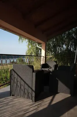 a patio with chairs and a fence on a deck at Vila Aleksandar in Krčedin