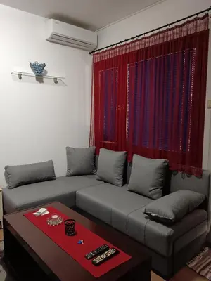 a living room with a couch and a red curtain at Beograd-Zvezdara in Belgrade