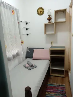 a small bed in a room with a window at Beograd-Zvezdara in Belgrade