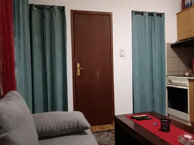 a living room with green curtains and a brown door at Beograd-Zvezdara in Belgrade