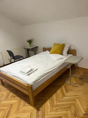 a large bed with a yellow pillow on top of it at Aliyah Hostel in Belgrade