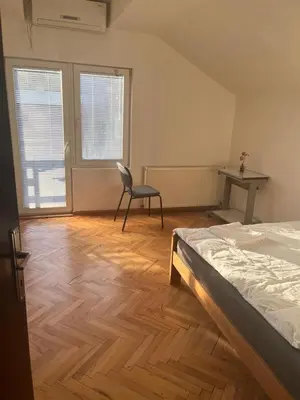 a bedroom with a bed and a chair and a desk at Aliyah Hostel in Belgrade