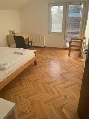 a room with a bed and a wooden floor at Aliyah Hostel in Belgrade