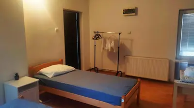 a bedroom with a bed and a lamp in it at Aliyah Hostel in Belgrade