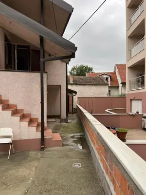 a house with a retaining wall next to a building at Aliyah Hostel in Belgrade