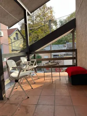 a patio with chairs and a table on a balcony at Aliyah Hostel in Belgrade