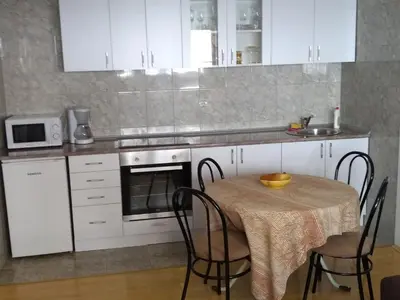a kitchen with a table with chairs and a microwave at Apartment Vojinovic in Arandjelovac
