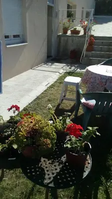 a patio with potted plants on a table and a bench at Apartment Vojinovic in Arandjelovac