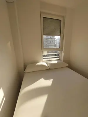 a small room with a bed and a window at DELTA CITY Apartment in Novi Beograd
