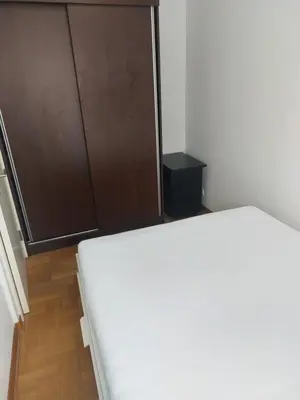 a bedroom with a bed and a closet and a door at DELTA CITY Apartment in Novi Beograd