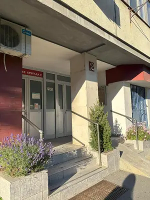 a building with purple flowers in front of it at Apartment Perfetto in Belgrade