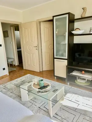 a living room with a glass table and a tv at Apartment Perfetto in Belgrade