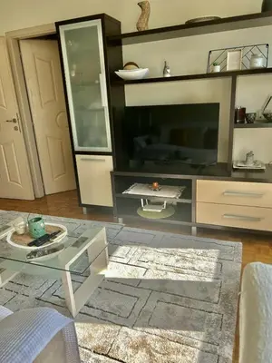 a living room with a glass table and a tv at Apartment Perfetto in Belgrade