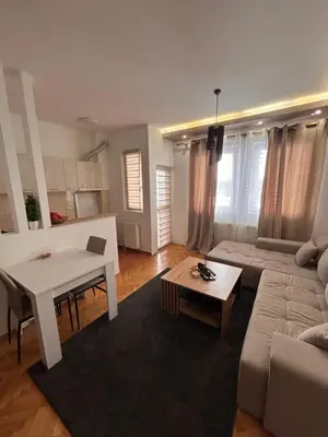 a living room with a white table and a couch at Centar stan na dan Ub in Ub
