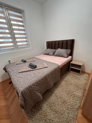 a bedroom with a bed with a blanket and a window at Centar stan na dan Ub in Ub