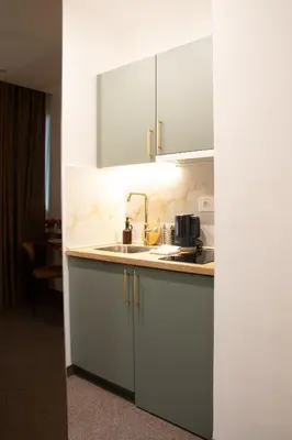 a kitchen with white cabinets and a sink at 1922 Downtown Apartments in Belgrade