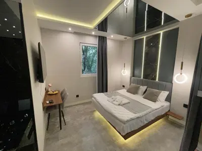 a bedroom with a bed and a table and a window at 1922 Downtown Apartments in Belgrade