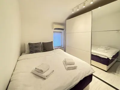 a bedroom with a large bed with towels on it at Downtown Cozy Apartment in Belgrade