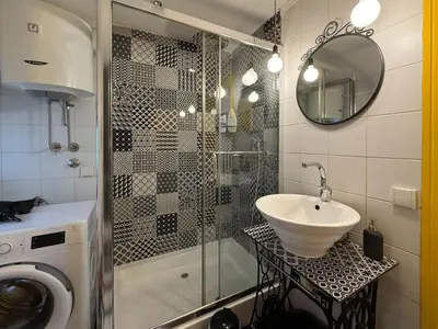 a bathroom with a shower and a sink and a mirror at Downtown Cozy Apartment in Belgrade
