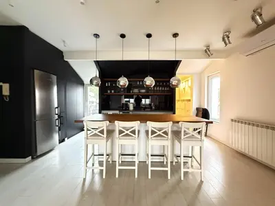 a kitchen with a wooden table and white chairs at Downtown Cozy Apartment in Belgrade