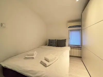 a small bedroom with a bed with towels on it at Downtown Cozy Apartment in Belgrade