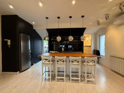 a kitchen with a large wooden table and stools at Downtown Cozy Apartment in Belgrade
