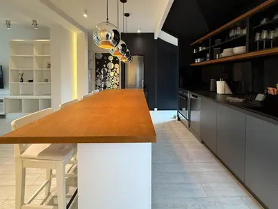 a kitchen with a long wooden table and white chairs at Downtown Cozy Apartment in Belgrade