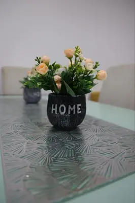 a black vase with flowers sitting on a table at Zmaj LUX 2 in Mladenovac