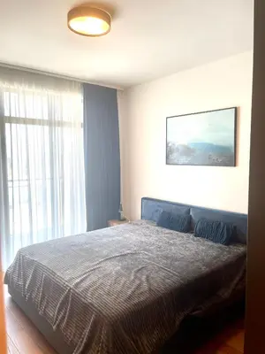 a bedroom with a bed and a large window at Melania in Belgrade