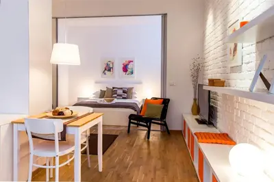 a bedroom with a bed and a table and chairs at Apartments Centro in Belgrade
