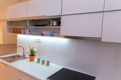 a kitchen with white cabinets and a sink at Apartments Centro in Belgrade