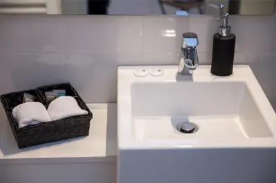 a bathroom with a sink and a basket of towels at Apartments Centro in Belgrade