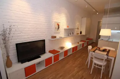 a living room with a tv on a white brick wall at Apartments Centro in Belgrade
