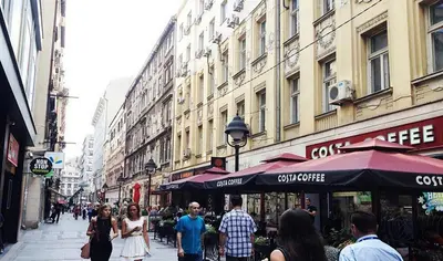 a group of people walking down a busy city street at Apartments Centro in Belgrade