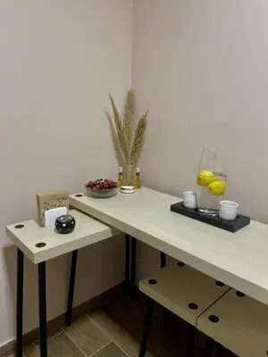 a table with a bowl of fruit and a vase of oranges at Jacuzzi Apartman PK Pančevo in Pančevo