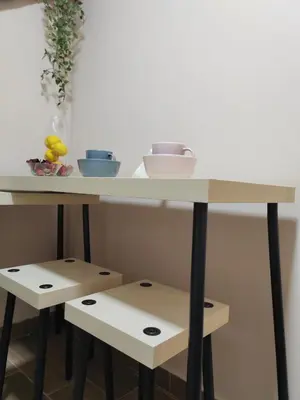 a table with two stools under it with a table with bowls at Jacuzzi Apartman PK Pančevo in Pančevo