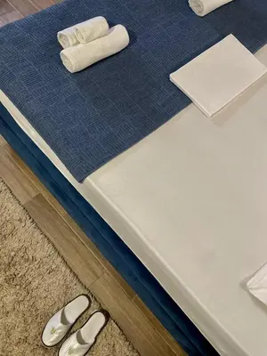 a bed with two rolled towels and two pairs of shoes at Jacuzzi Apartman PK Pančevo in Pančevo