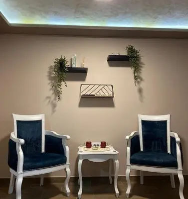 two chairs and a table in a room at Jacuzzi Apartman PK Pančevo in Pančevo