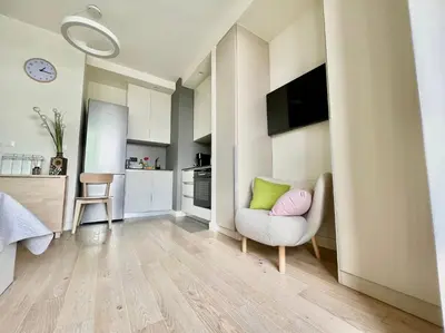 a living room with a chair and a kitchen at BW Studio Metropolitan in Belgrade
