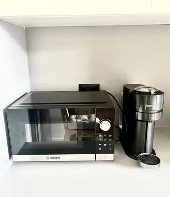 a microwave sitting on a counter next to a coffee maker at BW Studio Metropolitan in Belgrade