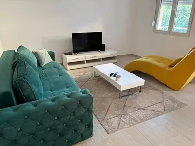 a living room with a green couch and a table at Zemun ES stan na dan in Belgrade