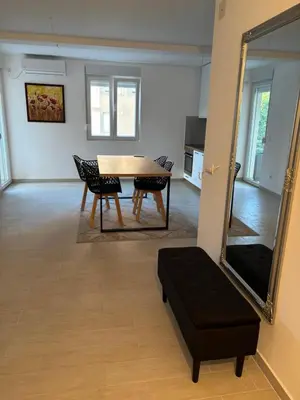 a dining room with a table and chairs and a mirror at Zemun ES stan na dan in Belgrade