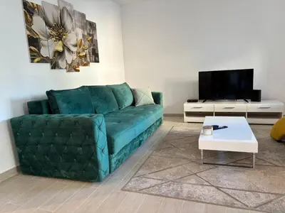 a living room with a green couch and a coffee table at Zemun ES stan na dan in Belgrade