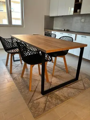 a wooden table in a kitchen with chairs around it at Zemun ES stan na dan in Belgrade