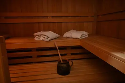 a sauna with two towels and a bucket in it at A-Frame Wellness Villa with Private Pool, Sauna & Jacuzzi near Belgrade in Koraćica