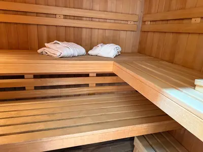 a wooden sauna with two towels sitting in it at A-Frame Wellness Villa with Private Pool, Sauna & Jacuzzi near Belgrade in Koraćica