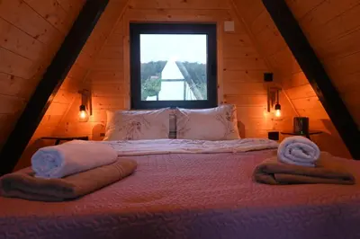 a bedroom with a large bed with towels on it at A-Frame Wellness Villa with Private Pool, Sauna & Jacuzzi near Belgrade in Koraćica