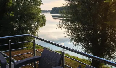a balcony with chairs and a view of a river at Elowen in Novo Selo