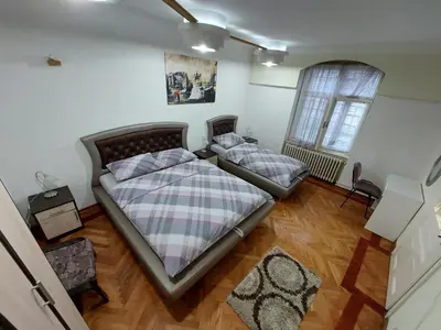 a bedroom with two beds and a window at Bukoleon Apartment in Belgrade